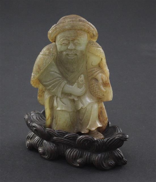 A Chinese celadon and russet skin jade figure of a fisherman, 18th / 19th century, 10cm., loss to right foot, carved wood stand